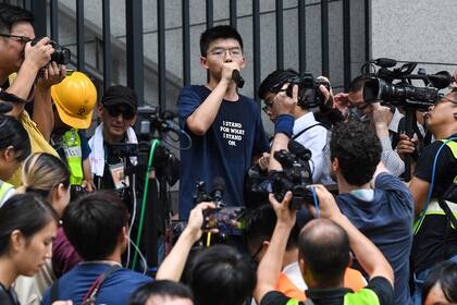El activista prodemocracia Joshua Wong habla con manifestantes frente a la sede de la policía en Hong Kong, en junio de 2019