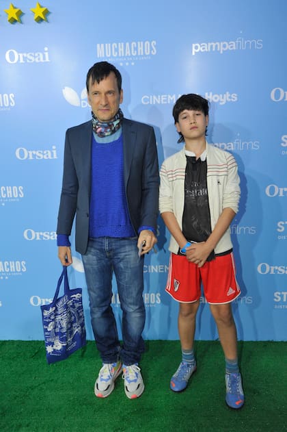 El actor Antonio Birabent combinó una remera celeste, un chaleco tejido, un saco azul y un pañuelo multicolor con un jean y zapatillas. Junto a él, su hijo, fanático de River
