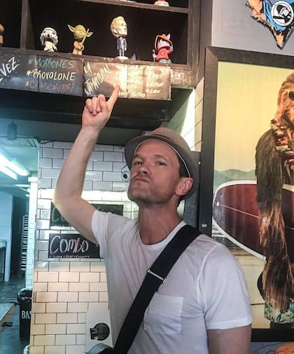El actor Barney Stinson señala a una figura de colección de él en Burger Joint