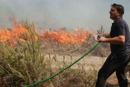 El actor intentando apagar el fuego para que no se acerque a su complejo de cabañas