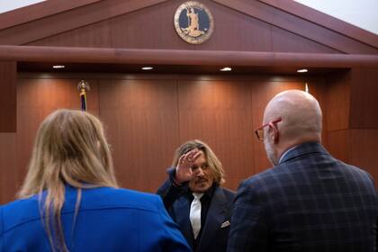 El actor Johnny Depp saluda en la corte de circuito del condado de Fairfax el 12 de abril de 2022 (Brendan Smialowski, Pool via AP)