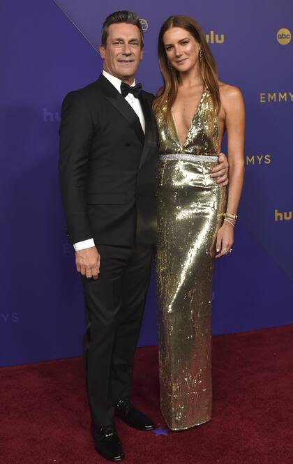 El actor Jon Hamm y su esposa, Anna Osceola, compartieron la caminata por la alfombra roja y se dejaron ver enamorados en la gala. Mientras él lució un clásico traje cruzado negro y un moño, ella brilló en un vestido dorado de escote profundo
