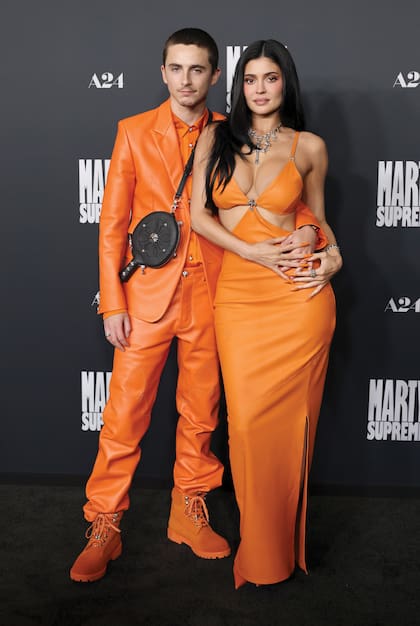 El actor posa con su novia Kylie Jenner. Él llevó un traje de
cuero brillante con camisa de seda y borcegos en el mismo color, que remató con un
estuche de paleta de ping pong a modo de bandolera. Por su parte, Kylie impactó con
un sensual vestido con aberturas triangulares. El escote en V estaba adornado con un
detalle en forma de cruz