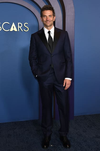 El actor y director Bradley Cooper, uno de los favoritos de la temporada de premios por su trabajo al frente y detrás de cámara en Maestro, lució muy elegante con un traje azul con negro que combinó con una camisa blanca