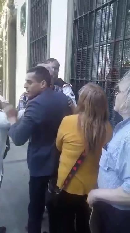 El agresor está tapado por el hombre de saco azul, que intenta evitar el ataque (captura de pantalla)