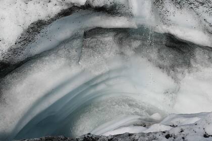 El agua fluye hacia una grieta a medida que el hielo se derrite en el glaciar Matanuska, un glaciar de valle de 43,5 km de largo que alimenta al río Matanuska, al noreste de Anchorage, Alaska