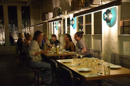 El ambiente fusiona materiales y formas de los ’60 con lámparas y acrílico verde