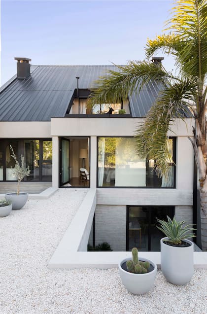 El anexo de hormigón tiene doble aprovechamiento, y se integra de manera orgánica a la casa: en la planta baja, como ampliación del espacio interior y, en altura, como terraza accesible para el dormitorio