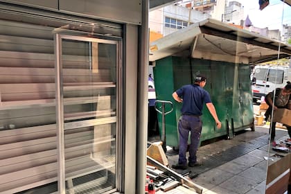 El antiguo puesto ubicado sobre la calle Cuenca, en Villa del Parque, es retirado mientras a su lado espera el nuevo mobiliario para ser instalado