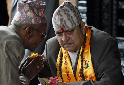 El antiguo rey de Nepal Gyanendra, a la derecha, escucha a un partidario en su cumpleaños número 64 en su residencia en Katmandú, Nepal, el 7 de julio de 2011.