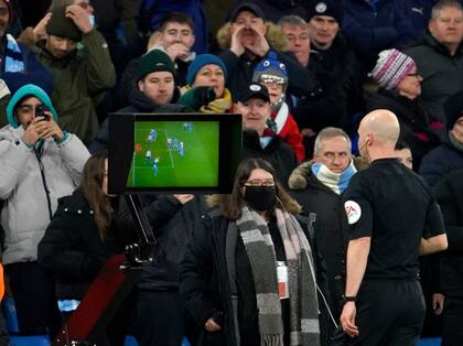 El árbitro Anthony Taylor chequea el VAR por la mano de Cuti Romero; al final cobró penal para Manchester City ante Tottenham