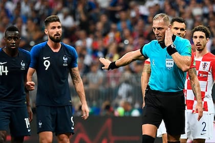 El momento en el que el árbitro argentino escucha las indicaciones de sus asistentes de VAR y señala el penal para Francia en la final del Mundial 2018