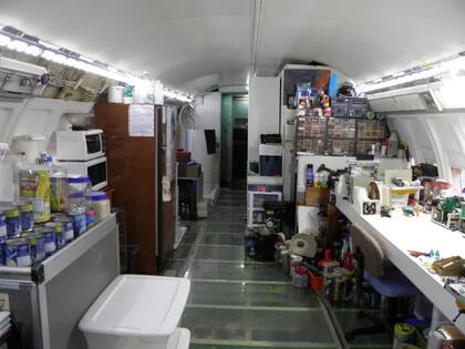 El área de cocina incluye un microondas, un horno tostador, una lavadora portátil y un carrito de avión como despensa