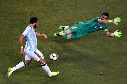 El argentino Gonzalo Higuaín se prepara para disparar sobre el portero chileno Claudio Bravo durante la final de la Copa América Centenario