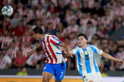 El argentino Julián Álvarez y el paraguayo Gustavo Velázquez van por el cabezazo en el duelo de la eliminatoria sudamericana al Mundial 2026 el jueves 14 de noviembre del 2024. (AP Foto/Jorge Saenz)