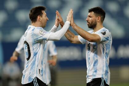 El argentino Lionel Messi, a la izquierda, celebra el segundo gol de su equipo desde el punto de penalti con su compañero Sergio Agüero durante un partido de fútbol de la Copa América contra Bolivia en el estadio Arena Pantanal de Cuiabá, Brasil, el lunes 28 de junio de 2021.