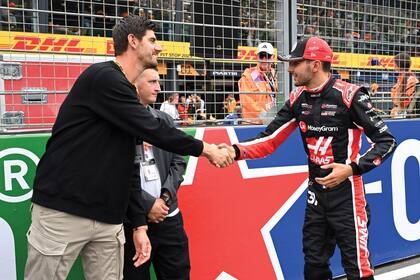 El arquero del Real Madrid, Thibaut Courtois, saluda al piloto francés Esteban Ocon