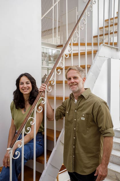 El arquitecto Javier Müller y la diseñadora Eugenia Avarello, en la escalera interna que hicieron en hierro, con escalones de pino tea recuperada y barandas de diseño vintage.