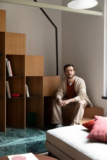 El arquitecto Matteo Soddu, parte del trío de StudioTamat, posa junto a la biblioteca del bajo escalera.