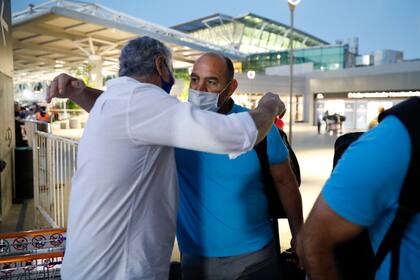 El abrazo del entrenador Mario Ledesma con un allegado, en la llegada a Ezeiza