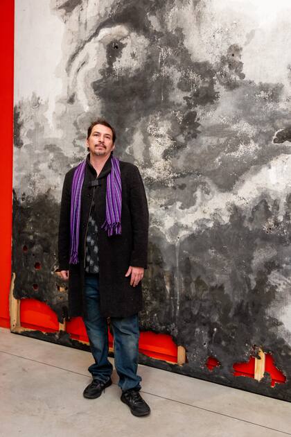 El artista Tomás Espina frente a su obra, que forma parte de la exposición "Cien caminos en un solo día", con curaduría de Jimena Ferreiro