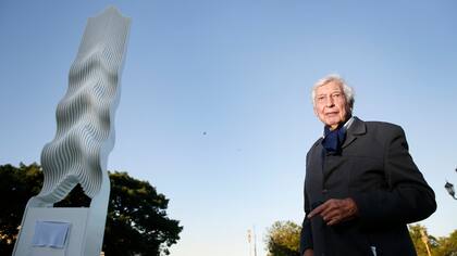 El artista y su escultura, al pie del puente por el que se accede a la Facultad de Derecho