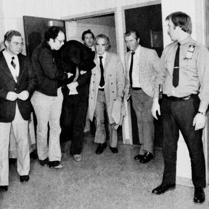 El asesinato de Lennon conmovió al mundo. Horas después de disparar y asesinar al músico, Marc Chapman es trasladado por las autoridades de New York