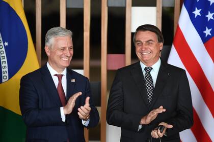 El asesor de seguridad nacional de Estados Unidos, Robert O Brien y el presidente brasileño, Jair Bolsonaro, aplauden durante una reunión en el Palacio de Itamaraty en Brasilia, el 20 de octubre de 2020