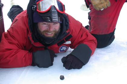 El astrobiólogo Daniel Glavin posa en 2012 junto a un meteorito que acababa de encontrar durante una expedición en la Antártida