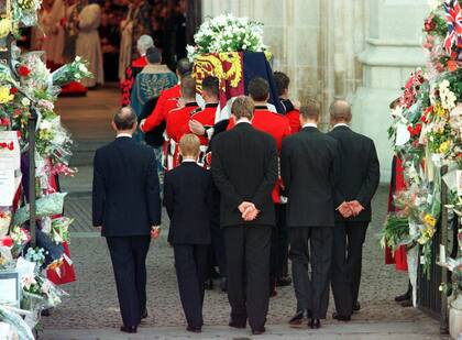 El ataúd de Diana, princesa de Gales, es llevado a la Abadía de Westminster por el grupo de portadores de la Guardia Galesa para su funeral, el sábado 6 de septiembre de 1997. A continuación están, de izquierda a derecha, el príncipe Carlos, el príncipe Harry, el conde Spencer, el príncipe William y el duque de Edimburgo. (AP Foto) 