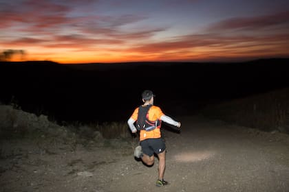 El atleta cipolleño Franco Paredes, cuando el sol se abre, desciende por un camino en el Trail Amanecer Comechingón, en Villa Yacanto