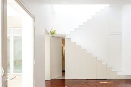 El bajoescalera alberga un baño completo con espacio para el lavarropas (donde se abre la puerta) y un toilette (puerta cerrada en el nivel del primer peldaño).