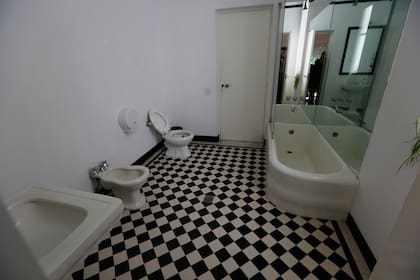 El baño blanco con el piso de damero original, típico de la época