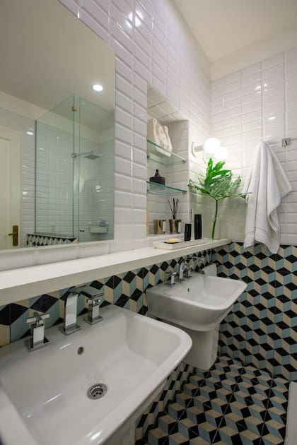 El baño de los chicos mezcla azulejos esmaltados con calcáreos diseñados por la arquitecta María Zunino y tiene bachas separadas.