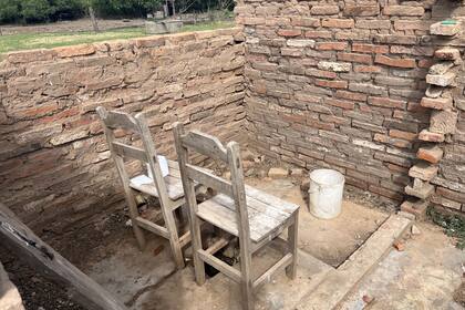 El baño de su casa consiste en un hueco en el piso con dos sillas puestas arriba para sentarse; no tiene techo y cuando llueve se mojan