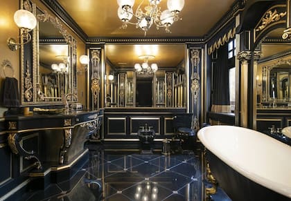 El baño está decorado en negro y dorado como parte del estilo dark glam