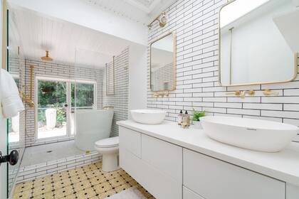 El baño está vestido por paredes con ladrillos blancos