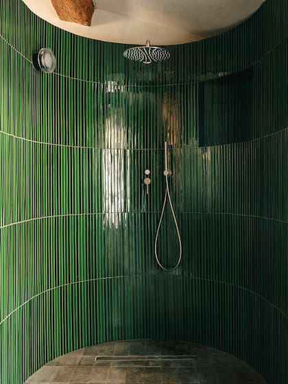 El baño principal, con un verde que se aparta de la paleta general pero que mantiene el acabado brillante buscado para multiplicar la luz de las ventanas pequeñas.