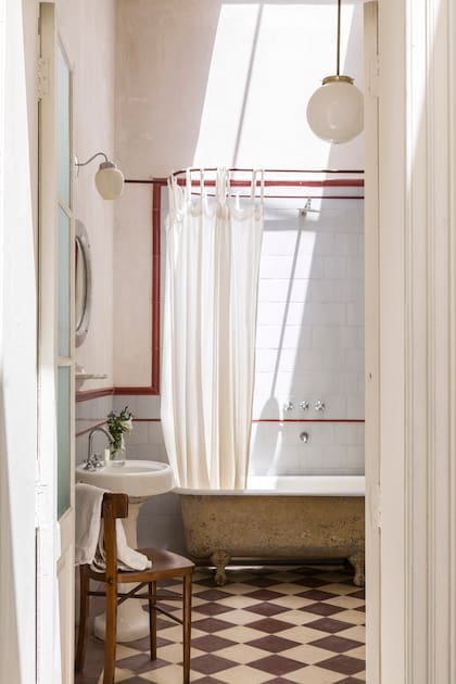 El baño se renovó respetando su estilo, pero cambiando la paleta del piso y los cerámicos. La bañadera de fundición, esmaltada por dentro y oxidada por fuera, resalta bajo el haz de luz que proyecta la claraboya original de 1891.