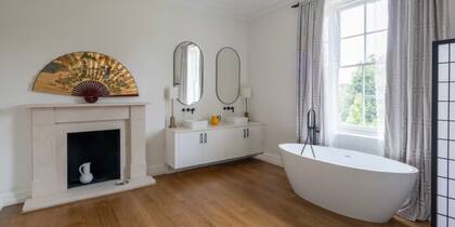 El baño tiene chimenea y una bañera exenta