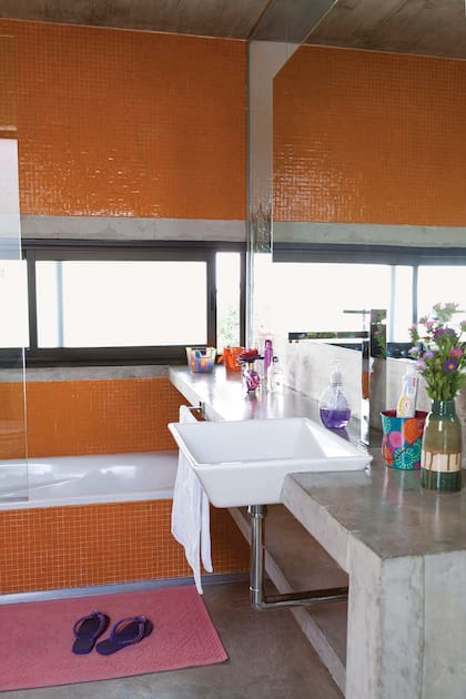 El baño tiene un alegre revestimiento de venecitas Murvi y grifería de FV.