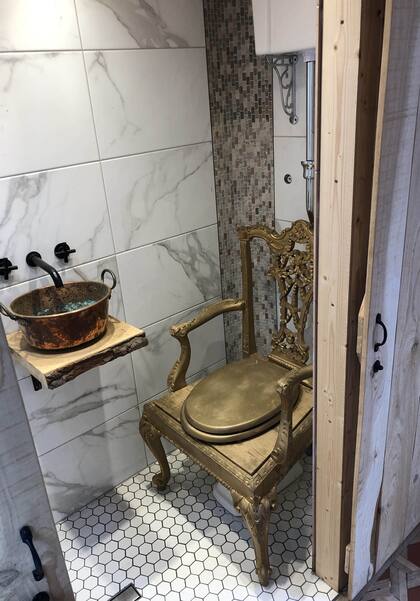 El baño tiene un trono dorado literalmente como inodoro y una cacerola vieja como bacha