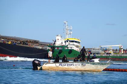Los rescatistas realizan maniobras en las cercanías del enorme buque carguero