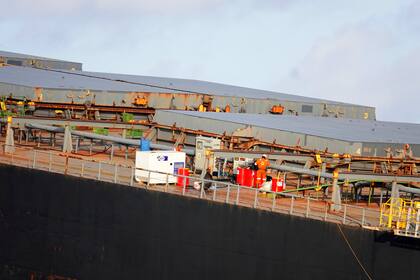 Un trabajador sobre la cubierta del buque carguero MV Wakashio