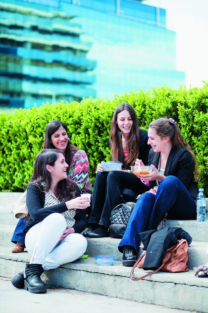 El barrio un día de semana, con gente que trabaja en la zona aprovechando el sol del mediodía