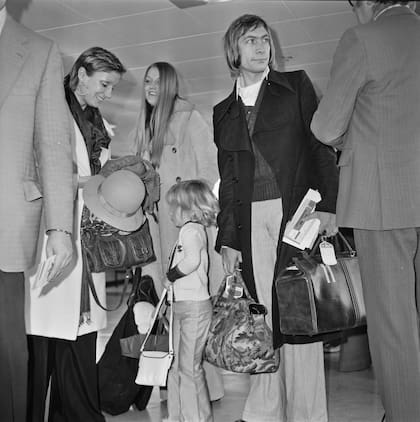El baterista Charlie Watts de la banda de rock The Rolling Stones en el aeropuerto de Heathrow en Londres, con su esposa Shirley y su hija Seraphina, el 5 de diciembre de 1972.