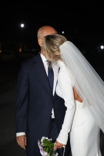 El beso de los recién casados. La novia lució un rosario y eligió orquídeas para su ramo