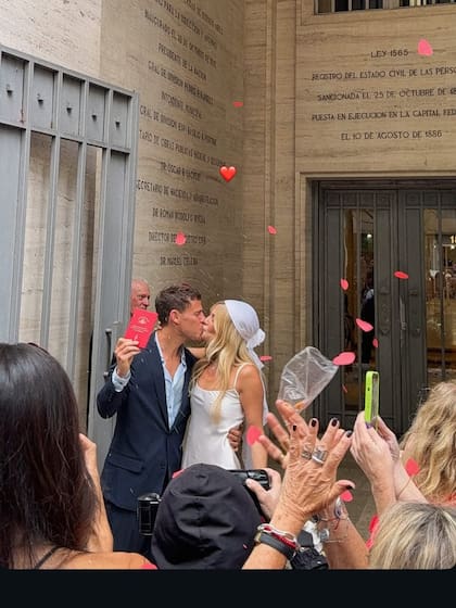 El beso de los recién casados, lluvia de arroz y de pétalos en la puerta del Registro Civil de la calle Uruguay