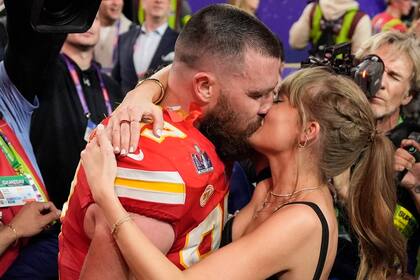 El beso del ala de Kansas City, Travis Kelce, y la cantante Taylor Swift, su mujer; otra estrella de los Chiefs, pero en otra vereda del mensaje norteamericano