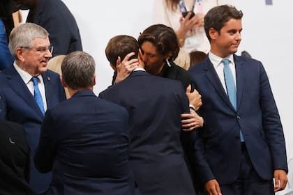 El beso entre la ministra de Deportes francesa, Amélie Oudéa-Castéra, y el presidente Emmanuel Macron, en el Trocadero, luego de la ceremonia inaugural de París 2024. (Odd ANDERSEN / AFP)